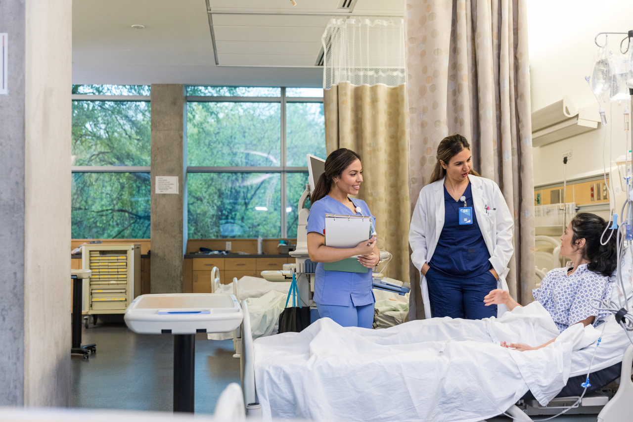 Female doctor and nurse talk to woman in outpatient clinic