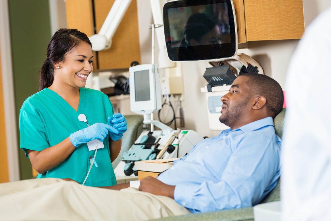 Phlebotomist preparing to insert line for blood donation in hospital