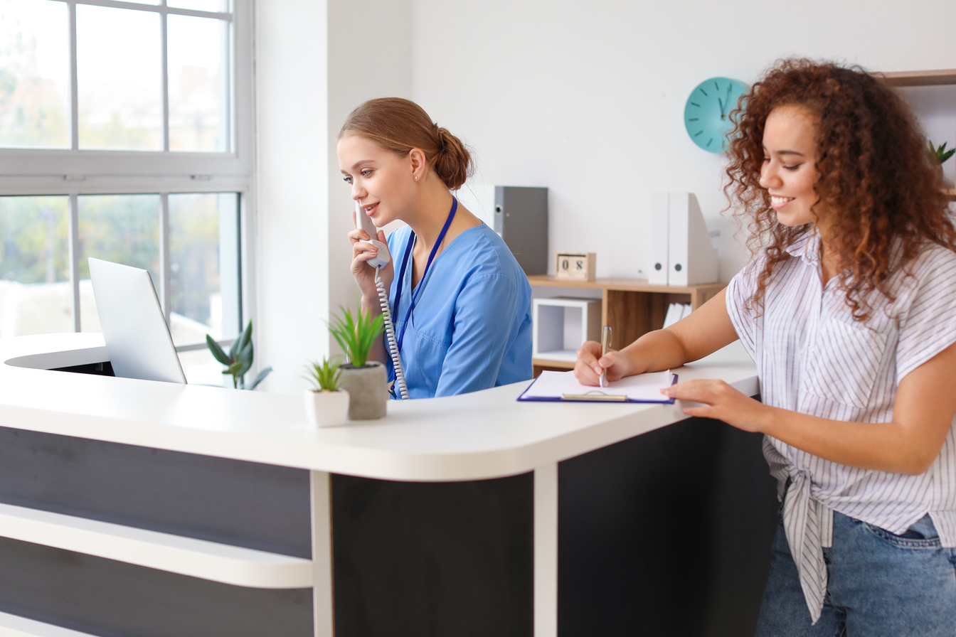 Female Receptionist Talking on the Telephone in a Clinic