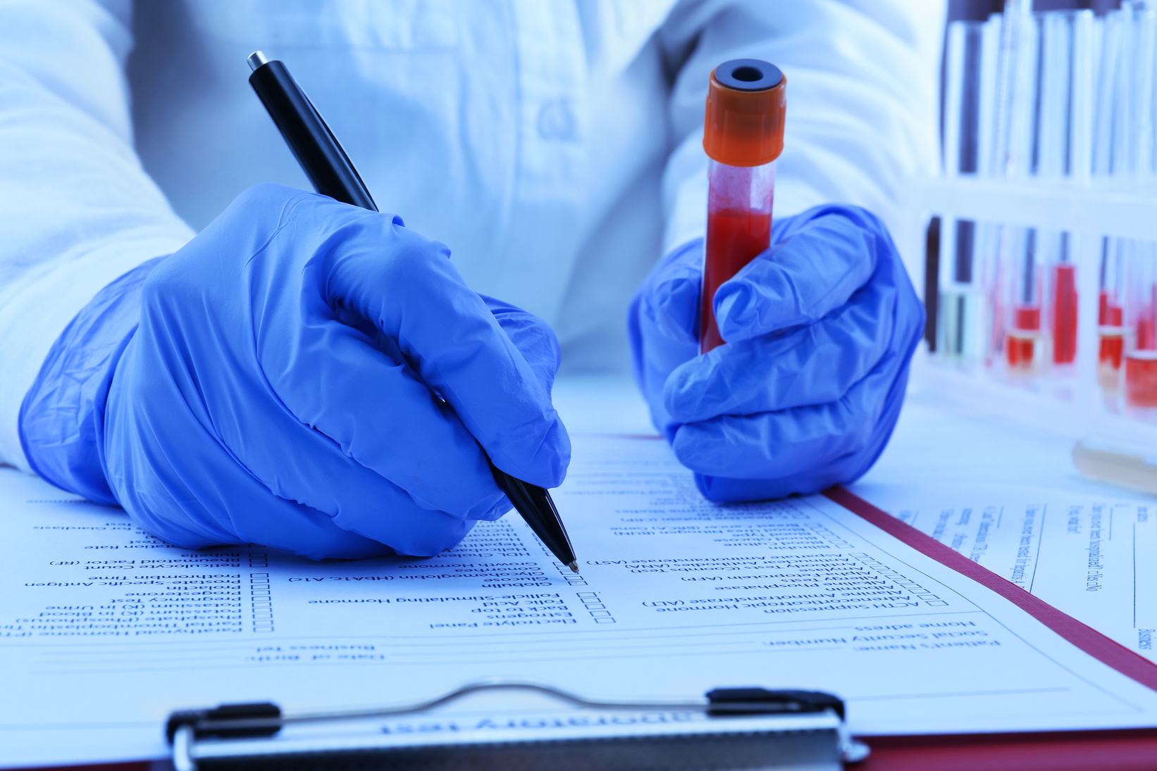 Hands with Blood Sample on Medical Report